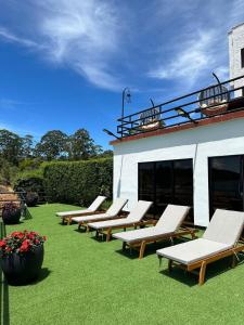 eine Reihe von Chaiselongues auf dem Rasen in der Nähe eines Gebäudes in der Unterkunft Villa Santa Luz in La Pradera + 12 Fotos
