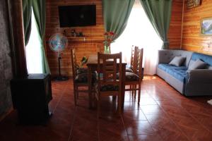 a living room with a couch and a table and chairs at Cabaña 1 Dos Laureles in Panguipulli