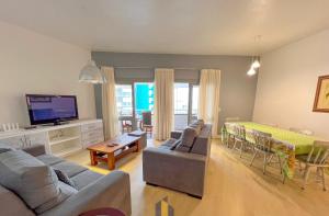 a living room with a couch and a dining room at Apartamento frente mar com 3 quartos in Torres