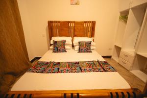 een slaapkamer met een bed met een hoofdeinde en kussens bij FREEDOM homes in Arusha