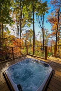 a jacuzzi tub on a deck in the woods at Dreams of Spring at Magnolia Treehouse in Wildwood