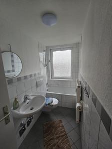a white bathroom with a sink and a bath tub at Moderne Wohnung gegenüber Bahnhof in Kassel