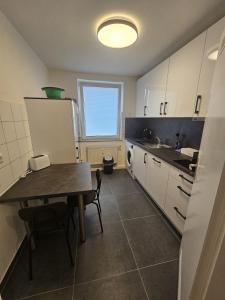 a small kitchen with a table and a refrigerator at Moderne Wohnung gegenüber Bahnhof in Kassel