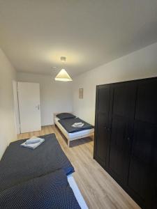 a bedroom with two beds and a large cabinet at Moderne Wohnung gegenüber Bahnhof in Kassel