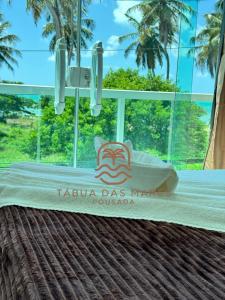 a bed with a sign that reads taja day market at Pousada Tábua das Marés in Japaratinga +20 photos