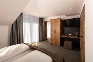 a hotel room with a bed and a television at Hotel AlpinaRos in Berchtesgaden +74 photos