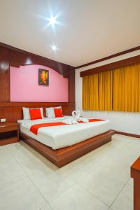 a bedroom with a large bed and a pink wall at Nova Patong in Patong Beach