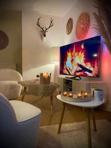 a living room with a tv and a table with candles at Maison Richet in Les Sables-dʼOlonne