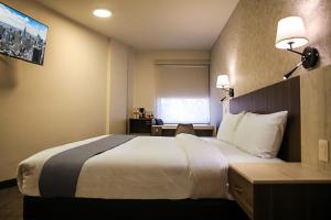 ein Hotelzimmer mit einem großen Bett und einem Schreibtisch in der Unterkunft JM & Suites in San Luis Potosí + 11 Fotos