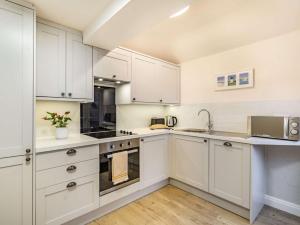 eine Küche mit weißen Schränken und einer Spüle in der Unterkunft 1 Bed in Lytham 86044 in Saint Annes on the Sea