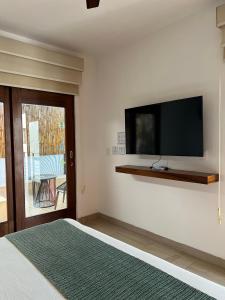 Un dormitorio con un televisor de pantalla plana en la pared. en Latino Hotel Boutique, en Tulum