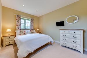 ReephamにあるPartridge Lodgeのベッドとドレッサーと鏡のある寝室