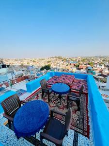 a patio with tables and chairs on a roof at Mystic View Jodhpur in Jodhpur
