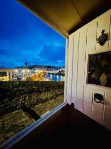 a room with a window with a view of a harbor at Mariners Cottage - Waters edge Fisherman's Cottage, Harbour & Sea Views & Free Dedicated Parking in Brixham