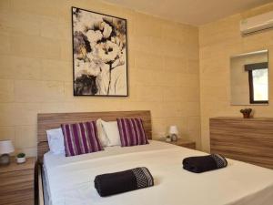a bedroom with a bed with two pillows on it at Dar il-Wied in Għajn il-Kbira