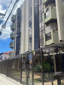 een hoog gebouw met glazen ramen ervoor bij Apartamento 3 suítes perto da Praia do forte e Passagem in Cabo Frio