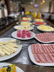 a table with plates of food and meats and cheese at Samba Betim in Betim