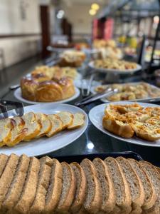 a buffet line with plates of bread and pastries at Samba Betim in Betim