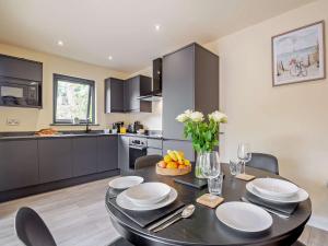 a kitchen with a dining room table with plates and flowers at 1 Bed in Conwy 96068 in Llangelynin +12 photos