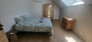 a small bedroom with a bed and a wooden dresser at la petite écurie in Soleymieu