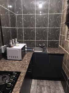 a kitchen with a sink and a microwave at The Good Samaritan 3 in Witbank