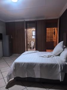 una camera da letto con un grande letto bianco in una stanza di The Good Samaritan 3 a Witbank