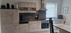 een keuken met een spoelbak en een fornuis bij VivaNatura Eifelferienappartement in Simmerath +16 foto's