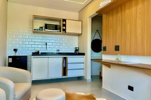 a kitchen with white cabinets and a counter top at Villa Cristalle - Campos do Jordão in Campos do Jordão