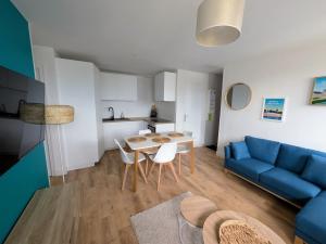 un soggiorno con un divano blu e un tavolo di Cozy and bright 3 bedrooms teleworking Vannes a Vannes