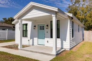 a white tiny house with a blue door at Free parking, Free WiFi 2 bed home in Tampa