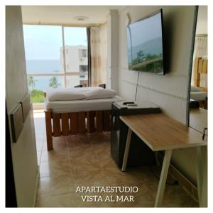 a bedroom with a bed and a desk and a mirror at apartaestudios luna azul rodadero in Gaira +6 photos