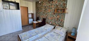a bedroom with a bed and a wall at Nella - Pokoje gościnne in Ostrowo