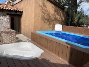 a jacuzzi tub on a deck next to a house at Loft Pienza 81-6: Charme toscano en Val’Quirico. in Santeagueda