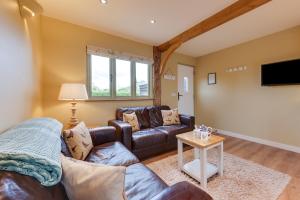 a living room with a couch and a tv at Pheasant Lodge in Reepham
