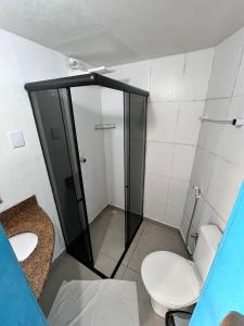 a small bathroom with a toilet and a shower at Pousada Mediterrânea in Pipa