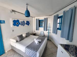 a living room with a white couch and blue curtains at Pousada Mediterrânea in Pipa +74 photos