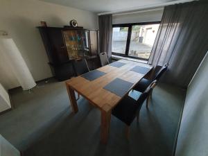 een houten tafel en stoelen in een kamer met een raam bij Ferienhaus Welling in Welling