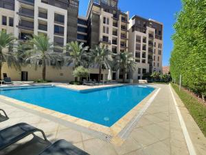 a swimming pool with palm trees and buildings at قرية الراحه مرسى زايد in Al Burj