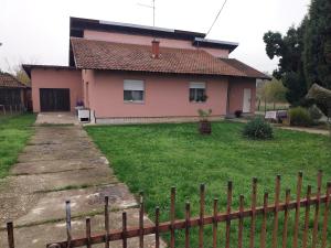 a pink house with a fence in front of it at Dve Breze 