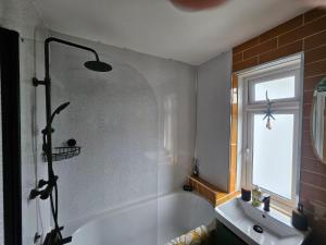 a bathroom with a shower and a tub and a sink at Drew Street Digs in Brixham +3 photos