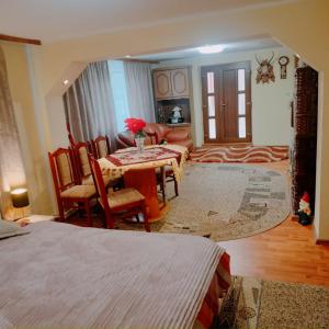 een slaapkamer met een tafel en stoelen en een woonkamer bij Casa Tudor-Nicolae in Borşa