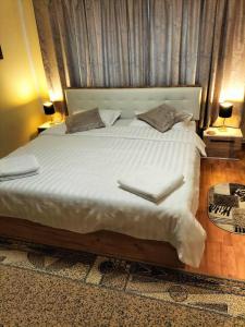 a bedroom with a large bed with two towels on it at Casa Tudor-Nicolae in Borşa +10 photos