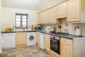 a kitchen with wooden cabinets and a washer and dryer at 3 Bed in Whitwell oc-h33498 in Whitwell