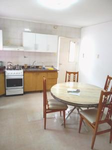 een keuken met een tafel en stoelen en een fornuis bij Depto cómodo y confortable in Olavarría