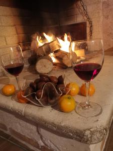 Una mesa con dos copas de vino y una chimenea en Dimora Visconti, en San Demetrio neʼ Vestini