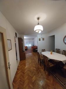 a dining room and living room with a table and chairs at Dve Breze 