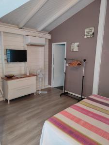 Un dormitorio con una cama, un escritorio y un televisor. en Lukila Bungalow At Rustine and Pompette's, en Saint-François