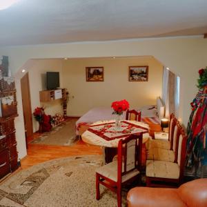een woonkamer met een bed en een tafel met bloemen erop bij Casa Tudor-Nicolae in Borşa