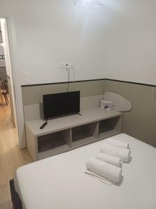 a room with a bed and a tv and towels at City Keys Volos in Volos +22 photos