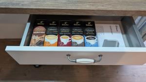 een lade met een doos met kopjes koffie bij FEWO VRONI - Wohlfühlambiente mit Stil und Terasse in Rattelsdorf